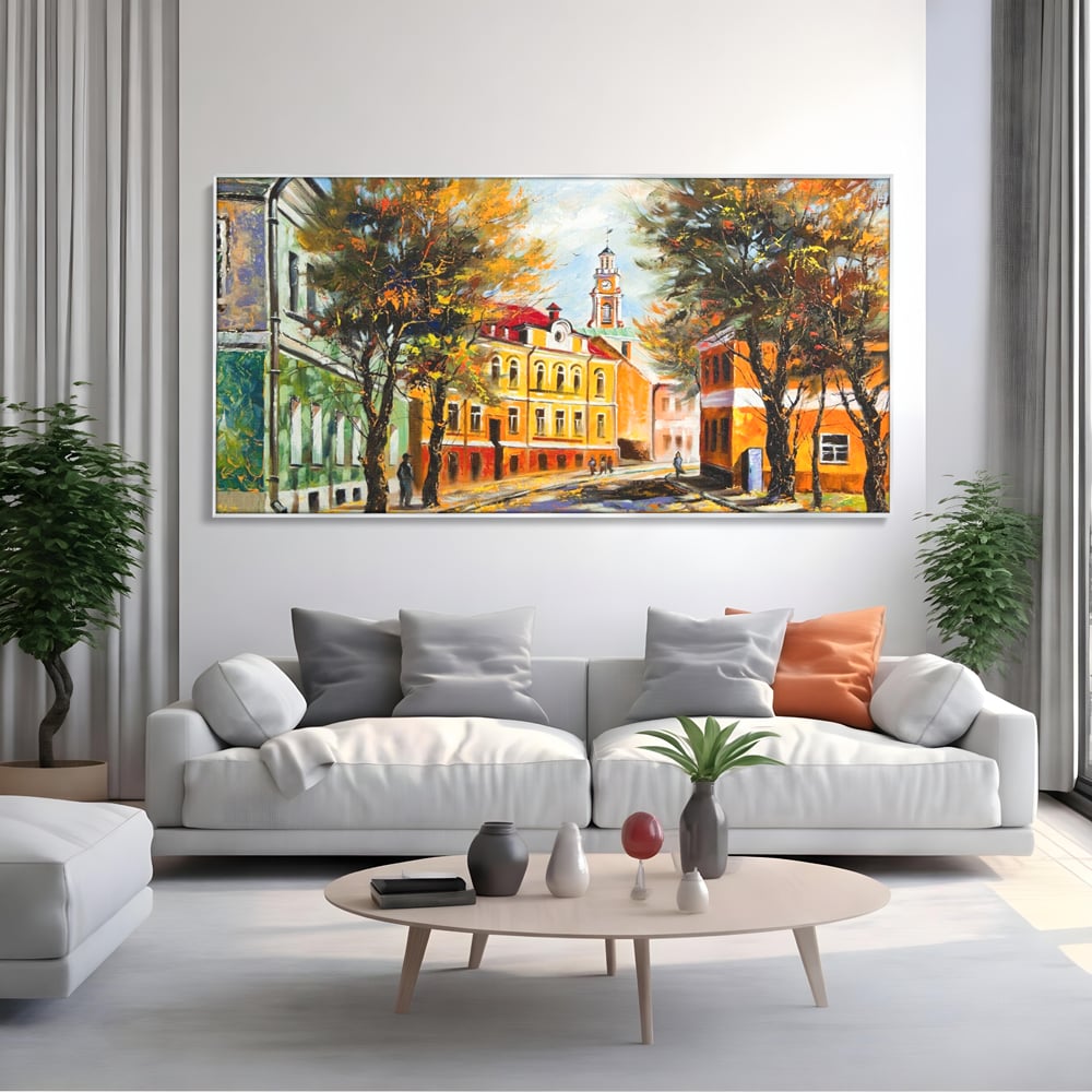 Tablou canvas cu pictura stradala cu peisaj de toamna, in rama de aluminiu argintiu, pe perete intr-un living